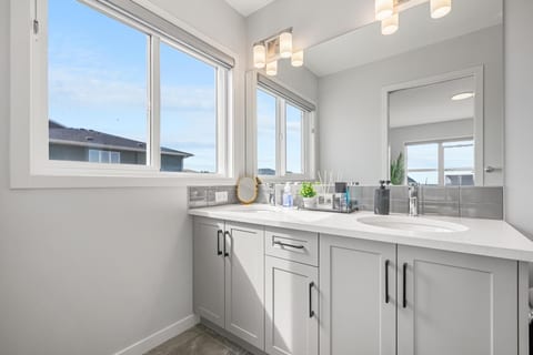 Bright modern bathroom with spacious vanity, large window, and stylish finishes
