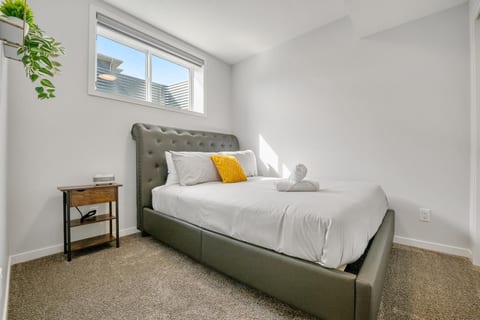 Bright, cozy bedroom with natural light and a plush upholstered bed