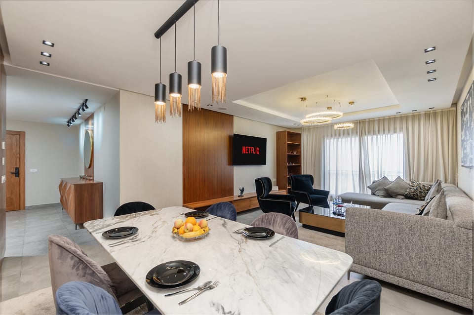 Stylish open-plan living with marble dining table and cozy lounge area