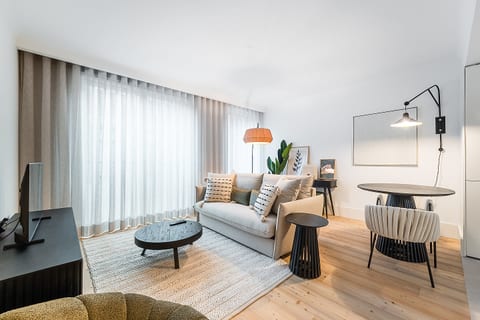 Bright, modern lounge with dining nook, wood floors, and chic layered lighting