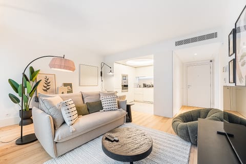 Bright modern lounge with sleek kitchen, A/C, and cozy designer touches.