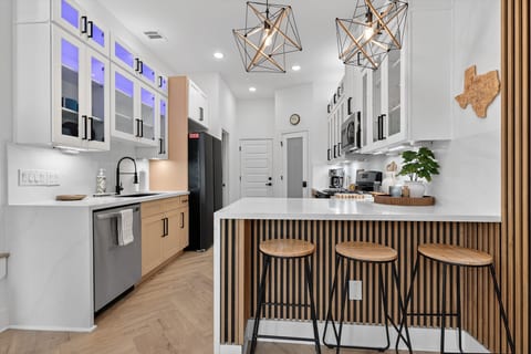 Modern chef’s kitchen: quartz island, gas range, seating for 3, unit A