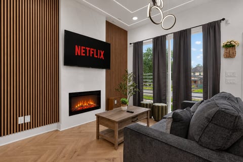 Chic lounge with smart TV, fireplace, balcony doors & cozy sofa