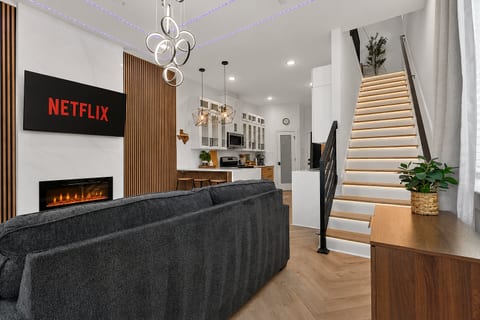Modern open-plan lounge & kitchen, fireplace, LED-lit staircase