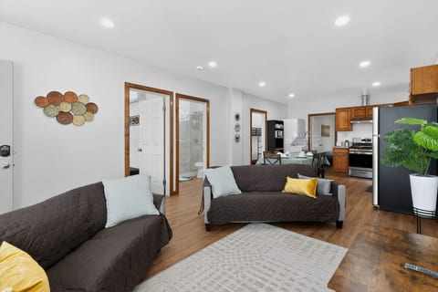Bright open-plan lounge, modern kitchen, and sleek glass-shower bath