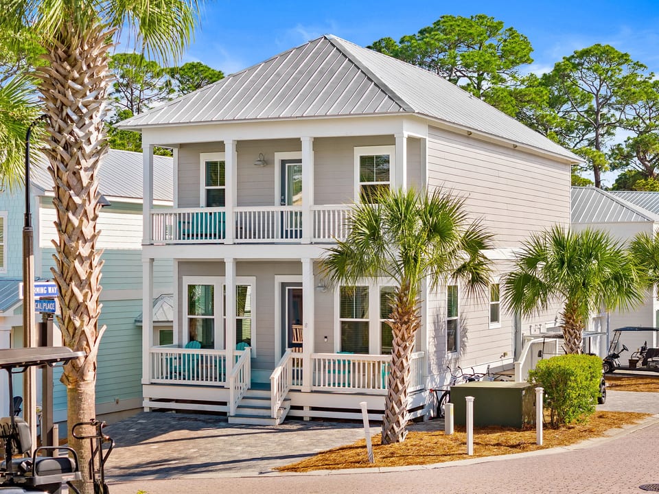 Charming coastal cottage with double porches in a palm-lined lane