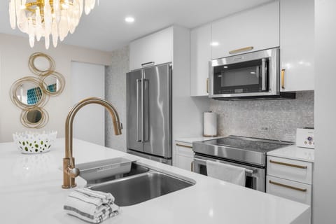 Kitchen detail with gooseneck faucet, gas range, and French-door refrigerator