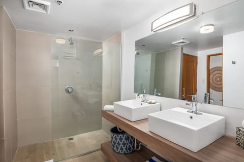 Modern bathroom with double sinks and a large walk-in shower.