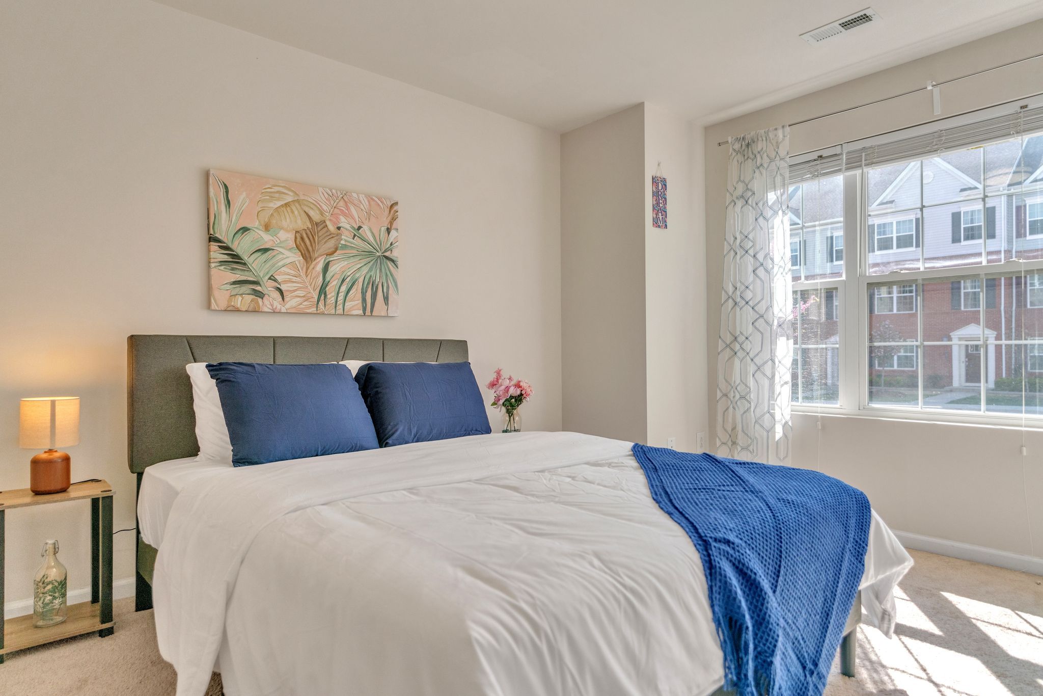 Bright sunlit bedroom with plush bedding and stylish blue accents