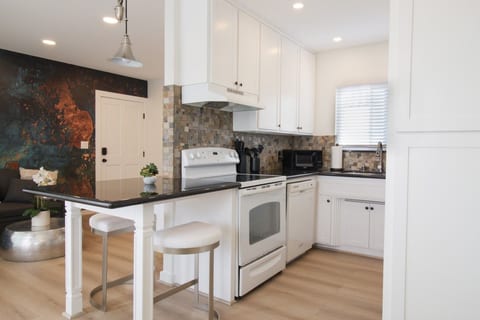 Full kitchen with white range, oven and breakfast bar