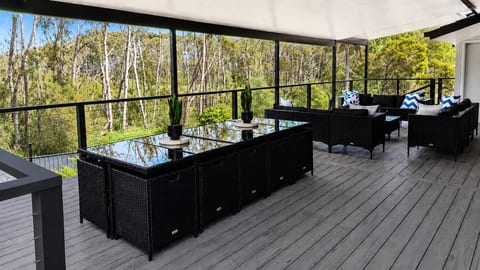 Upstairs Back Balcony : A view across the upper back deck at Skye’s Beach House Malua Bay, looking out to the natural backdrop behind the property.