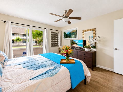 Rest easy in a cheerful coastal bedroom with sea turtle details, soft island colors, and your private lanai just steps away.