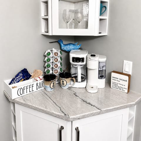 Charming coffee bar with dual brewers, stocked pods, and elegant marble counter