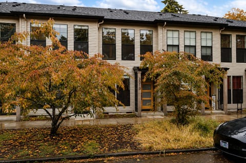 Charming townhouse exterior with seasonal trees and welcoming entry