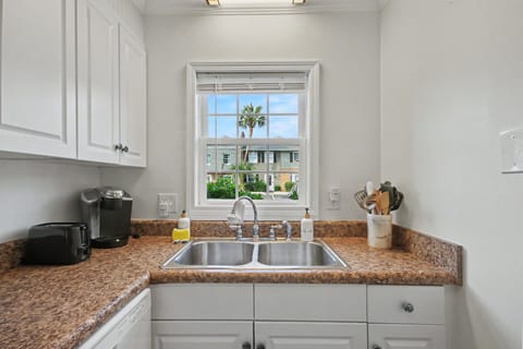 Bright kitchen with double sink, ample counters, and sunny window view
