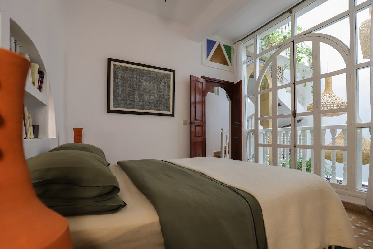 A bright and soothing room with large windows, a clean design, and a warm atmosphere for restful nights. Dar Mestoura · Bright Riad · Terraces with Sea View