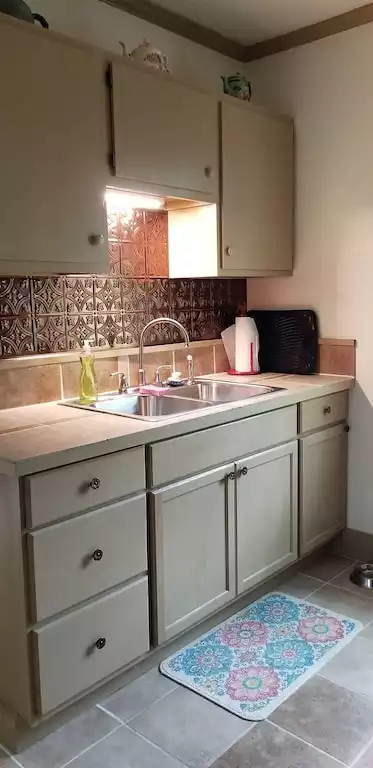 Kitchen sink and counter. Table service for 4 people is provided - Hummingbird Cottage - Fort Spring