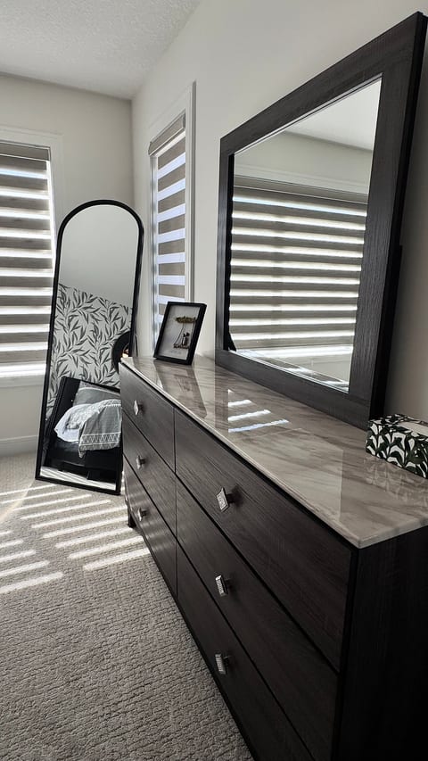 Modern bedroom dresser with large mirror and beautiful natural light