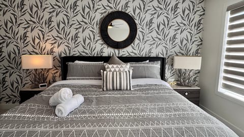 Stylish king bedroom with botanical accent wall and elegant modern décor