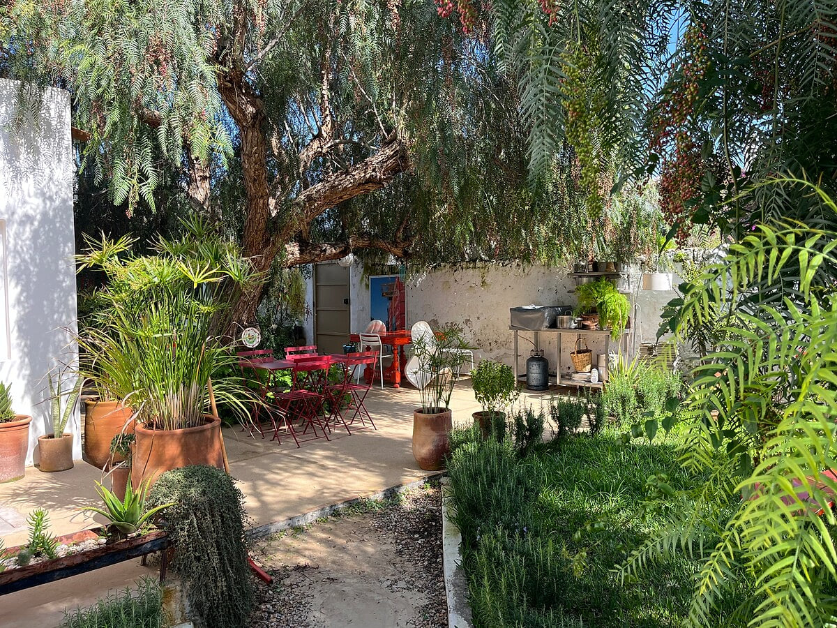 View of an enchanting garden with a dining area and lush greenery. A unique atmosphere for a relaxing stay. Dar Cocottes Chill · Pool Gardens
