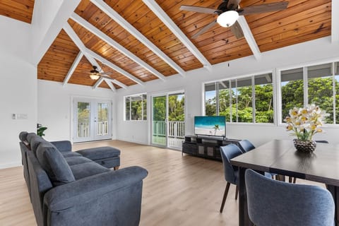 Bright open living and dining area with vaulted wood ceilings and lanai access