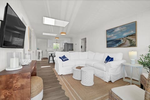 Bright coastal living room with spacious sectional and open kitchen