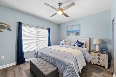 Retreat to the primary bedroom featuring a comfortable king-size bed and calming coastal décor for restful nights.