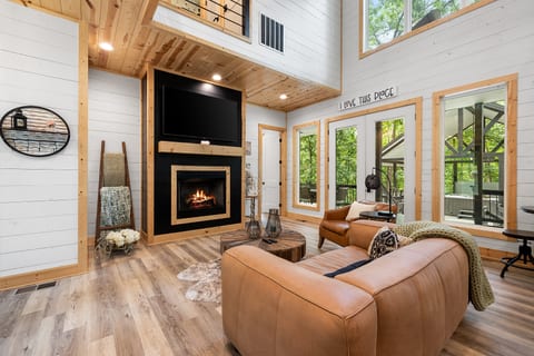 Soaring ceilings, cozy fireplace nights, and walls of windows to nature 🌲