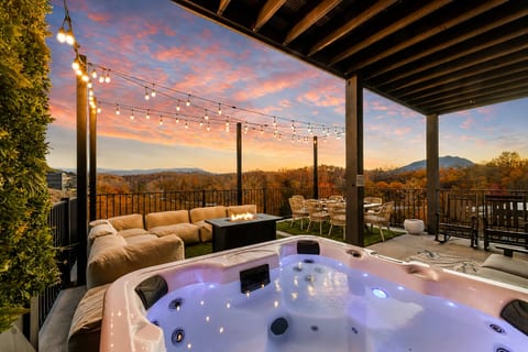 Private hot tub deck with fire table, string lights & sunset mountain views