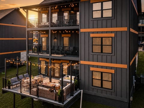 Sunset patio with string lights, hot tub, and spacious covered balconies