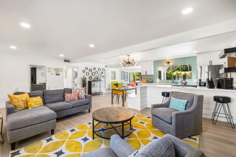 Bright open living room w/ comfy seating, colorful accents, & easy flow for relaxing or gathering together.