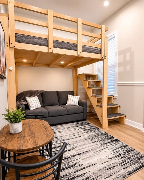 Make yourself at home in this thoughtfully designed loft-style. The custom-built loft bed creates a unique, inviting atmosphere, while the cozy seating area below offers the perfect place to relax, watch a movie, or unwind after a day of exploring.