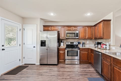 Full stainless kitchen — French door fridge, electric range, microwave, and dishwasher. Coffee and tea station always stocked for guests.