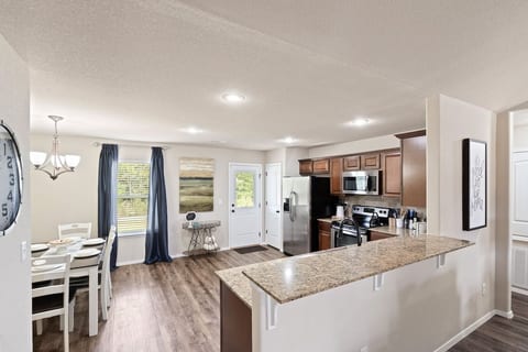 Granite peninsula bar connects kitchen and living. Seats 2 with sightlines to the whole living space — great for entertaining.