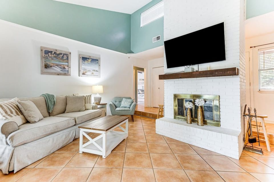 Vaulted ceilings and coastal hues set the tone for cozy nights in. Sink into the plush sofa, flip on a movie by the fireplace, and let the kids curl up with a beachy throw. A bright, breezy living room made for slowing down together
