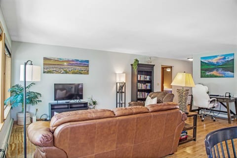 Living room with 40" Smart HDTV, seating for 4, bookshelf with books and games.