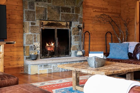 Gather around the stone wood-burning fireplace after a day outdoors