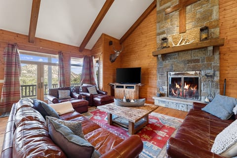 Cozy lodge living room with wood-burning fireplace and mountain views