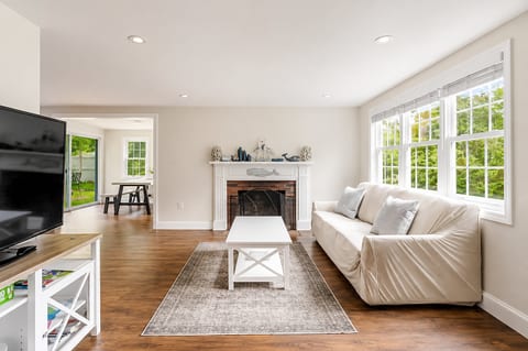 Bright living room with fireplace, big windows, and easy backyard access