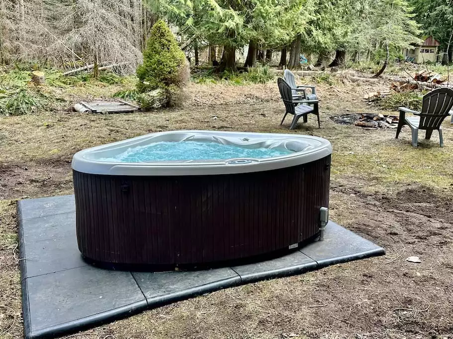 Hot tub with a view to the forest beyond. Hot tub with a view to the forest beyond. - Storybook Cabin - Ashford