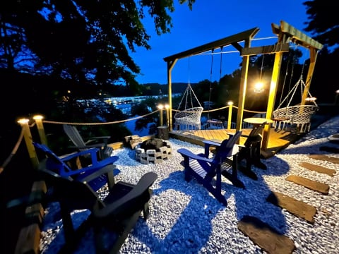 New fire pit area with solo stove, polywood chairs, and swings