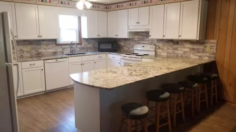The kitchen is spacious, well equipped with plenty of utensils and appliances.