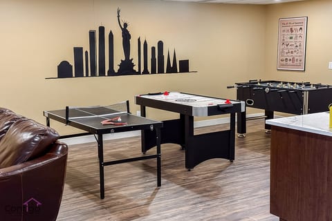 Fun-filled game room with ping pong, air hockey, and foosball tables, ideal for family and friends to unwind and play together.