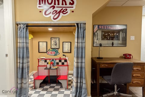 Cozy retro diner-themed nook perfect for work or relaxing, featuring a spacious desk and comfortable seating in the heart of Lendrum House.
