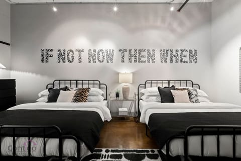 Bedroom with two king-size beds and modern industrial design.
