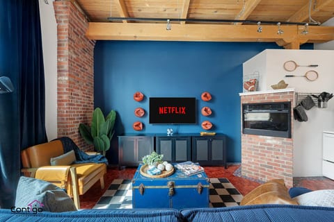 Lounge with bold style! Kick back with Netflix, a modern fireplace, and playful decor in this central loft.