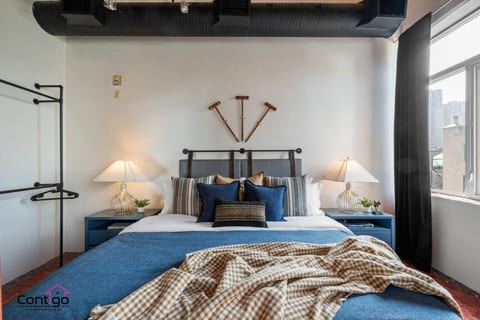 Comfortable king-size bed in a bright, loft-style studio. No walls, just open space and natural light — perfect for relaxing after a day exploring downtown.