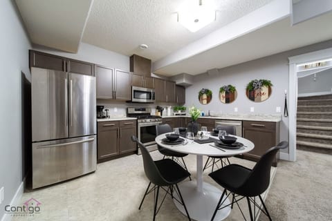 Modern full kitchen with stainless steel appliances and a cozy dining area, perfect for family meals and cooking together.