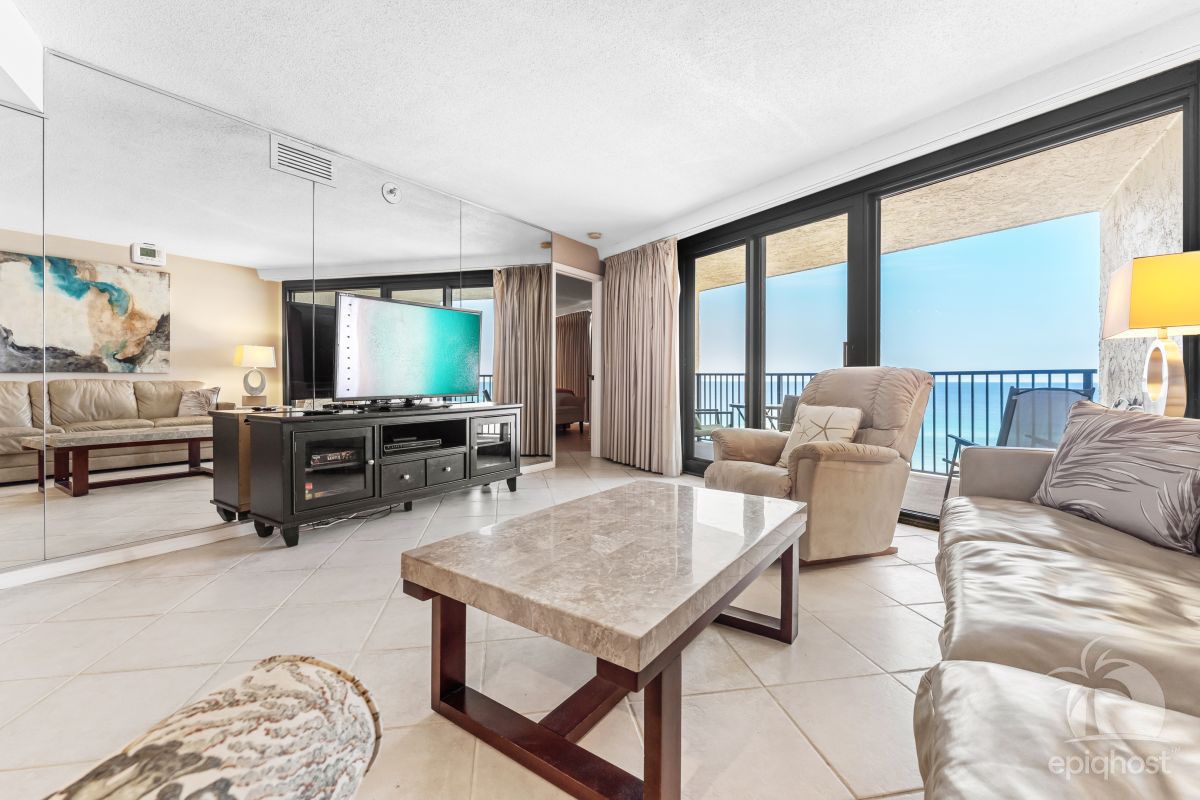 Spacious living area with floor-to-ceiling gulf views and private balcony access