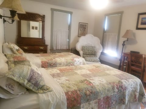 Wicker bedroom has two twin beds, closet space, dresser, and desk.
